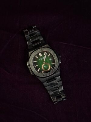 A luxury wristwatch with a green dial and metal bracelet placed on a dark purple velvet surface.