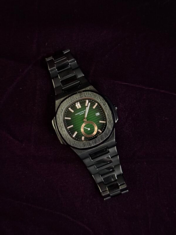A luxury wristwatch with a green dial and metal bracelet placed on a dark purple velvet surface.